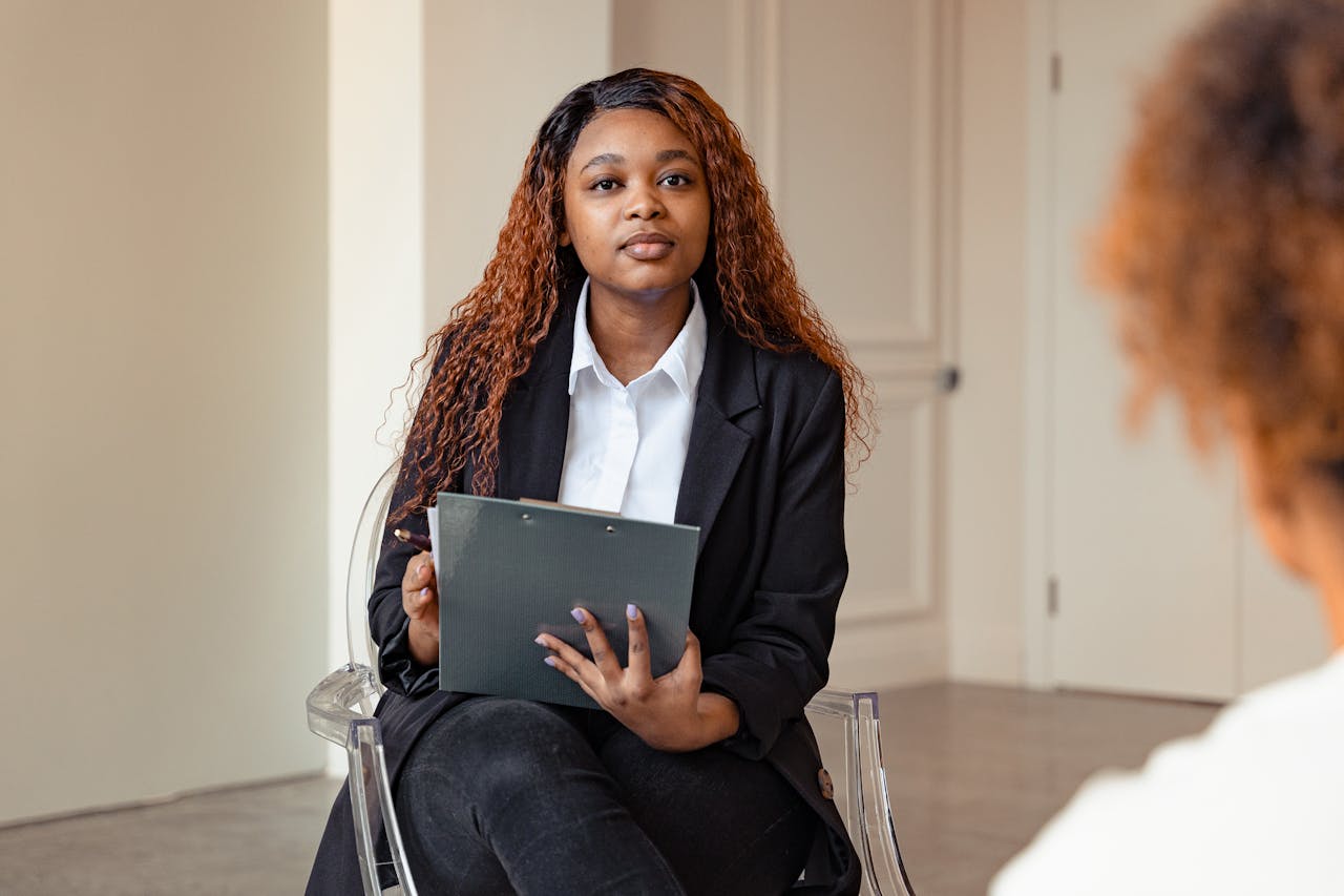 A counselor attentively listens during a therapy session, fostering mental health support.